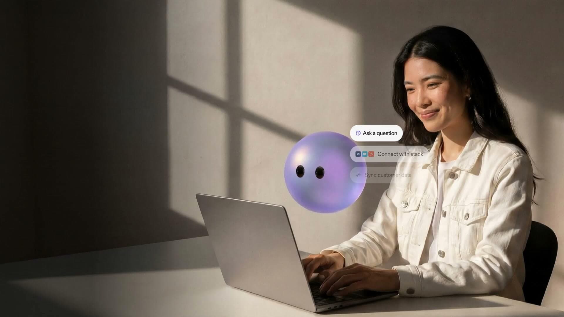 Customer service agent working at a laptop beside a Lyro orb