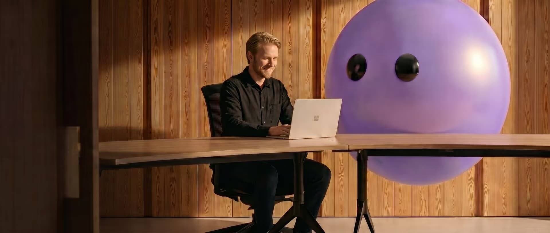 A support agent working at a laptop beside the purple Lyro mascot