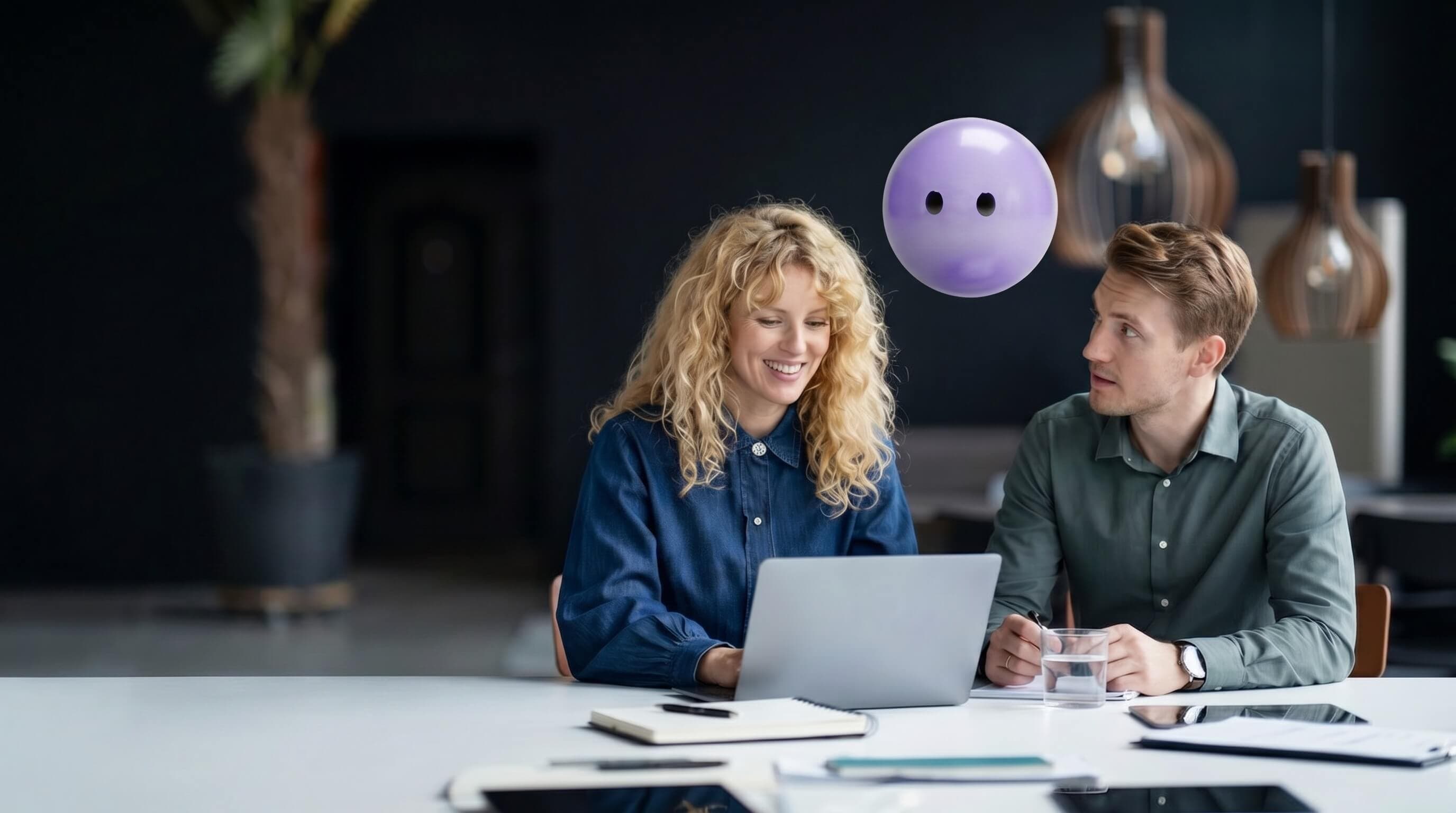 Two support agents collaborating at a laptop