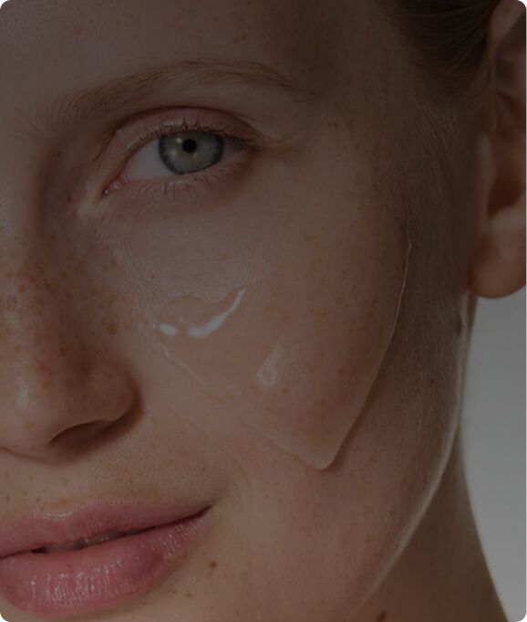 Close-up of a person applying skincare product under their eye